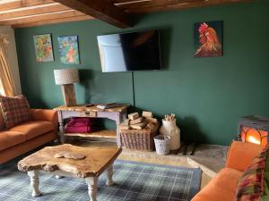a living room with a couch and a tv on the wall at Beck cottage in Rosedale Abbey
