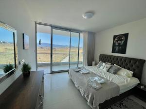 a bedroom with a large bed and a large window at Sea Breeze Suite by the Sea in Vokolidha