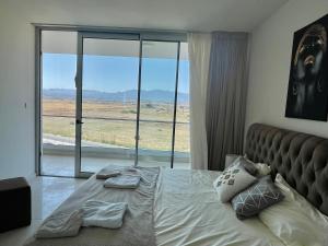 a bedroom with a large bed with a large window at Sea Breeze Suite by the Sea in Vokolidha