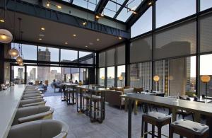 a restaurant with tables and chairs and large windows at Canopy By Hilton Columbus Downtown Short North in Columbus