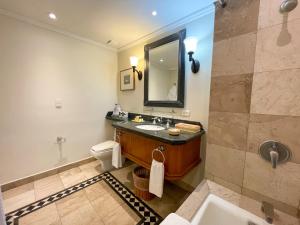 a bathroom with a sink and a toilet and a mirror at Pierre Mundo Imperial Riviera Diamante Acapulco All Inclusive in Acapulco +51 photos