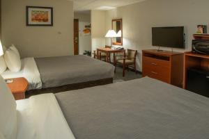 a hotel room with two beds and a flat screen tv at Quality Inn Stadium Area Green Bay Stadium in Green Bay +28 photos