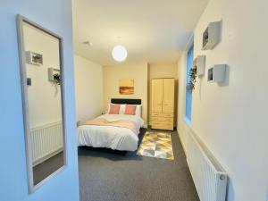 a small bedroom with a bed and a mirror at Quarto 4 casa compartilhada no L7 in Liverpool