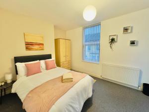 a bedroom with a large bed and a window at Quarto 4 casa compartilhada no L7 in Liverpool