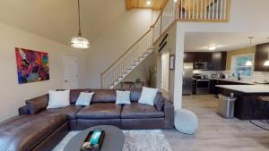 a living room with a brown couch and a kitchen at The Mendon House in Killington