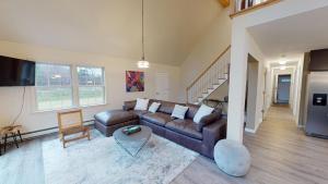 a living room with a leather couch and a table at The Mendon House in Killington