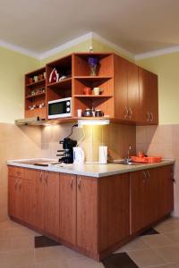 een keuken met houten kasten en een aanrecht bij Mars II. Apartman in Szeged