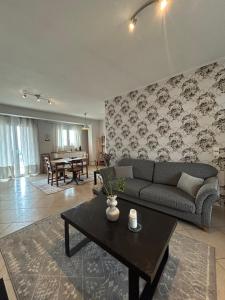 a living room with a couch and a table at ΗΣΥΧΟ ΚΑΙ ΑΝΕΤΟ ΔΙΑΜΈΡΙΣΜΑ in Lamía