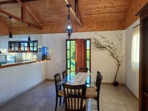 une cuisine et une salle à manger avec une table et des chaises dans l'établissement Chalés Alto da Serra 1, à Campos do Jordão