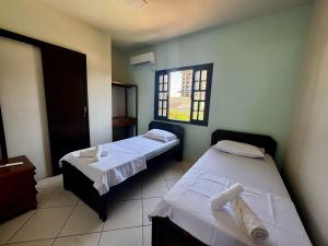 ein Zimmer mit zwei Betten und einem Fenster in der Unterkunft Casa Frente Mar na Avenida Beira Mar 3 Itapoa in Itapoa