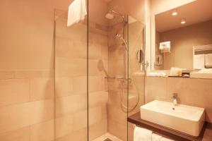 a bathroom with a glass shower and a sink at Hotel Platzhirsch in Fulda