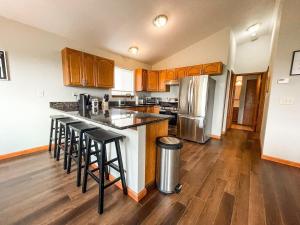 a kitchen with wooden cabinets and a counter top with bar stools at Secluded Cabin_fishing_hiking_relaxing_fireplace in Florissant