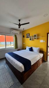 a bedroom with a large bed with a yellow wall at Ta Cabana Beach house-Pondicherry in Pondicherry
