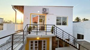 a white house with a staircase and a balcony at Ta Cabana Beach house-Pondicherry in Pondicherry