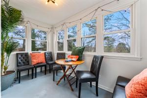 a room with chairs and a table and windows at Hapeville Hideaway - Relaxing yard, airport nearby in Atlanta