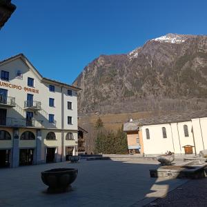 a building in a town with a mountain in the background at Appartamento Terme view in Pré-Saint-Didier +51 photos