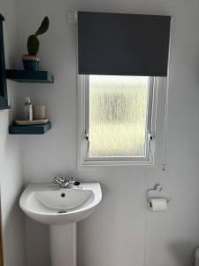 a bathroom with a sink and a window at Padstow Holiday Base Bright Two Bedroom Lodge at Seven Bays in St Merryn +24 photos
