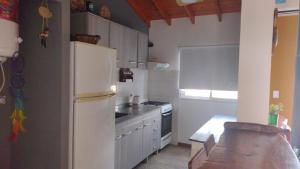 een keuken met een witte koelkast en een fornuis bij cabañas sunrise in Merlo +2 foto's