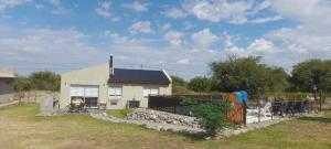 een klein wit huis met een hek ervoor bij cabañas sunrise in Merlo