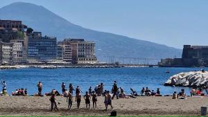 un grupo de personas en una playa cerca del agua en Lo Studio della Riviera, en Nápoles