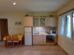 a kitchen with a table and a white refrigerator at Ktima Pyroessa Apartments - Yellow Apartment in Thános