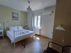 a bedroom with a white bed and a window at Ktima Pyroessa Apartments - Yellow Apartment in Thános