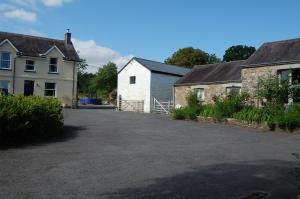 a driveway in front of a white house at Dinefwr Cottage in Carmarthen