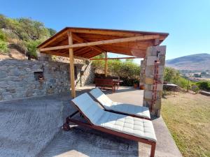 a patio with a bench and a stone wall at Ktima Pyroessa Apartments - Yellow Apartment in Thános