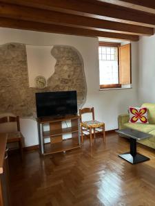Una sala de estar con televisión y un sofá. en Desenzano del Garda Mirella house, en Desenzano del Garda