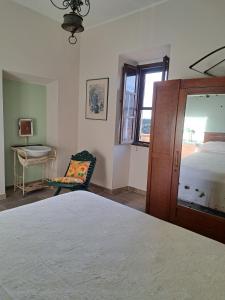 a bedroom with a bed and a chair and a window at casa Marino in Tuoro sul Trasimeno