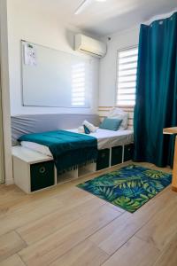 a room with two beds and a blue curtain at Appartement design & confort- Route des hôtels in Le Gosier