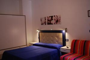 シルミオーネにあるAppartamenti Cornelianiのベッドルーム1室(ベッド1台、椅子付)