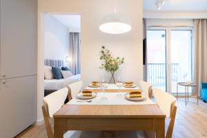 Un comedor y una sala de estar con mesa y sillas. en Parkcity Centrum, en Katowice