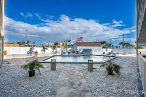 einen Pool mit Palmen im Innenhof in der Unterkunft Stunning Ocean Views STEPS from the Beach with Pool! Fabulous 4th Floor Studio! in New Smyrna Beach
