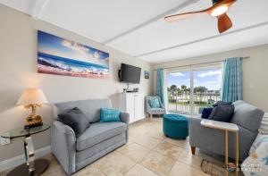 a living room with a couch and a tv at Spectacular Ocean View STEPS from the Beach and Pool! Third Floor Studio! in Edgewater