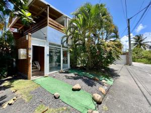 a house with a green lawn in front of it at Auberge de jeunesse El Poyito Kite & Surf Camp in Sainte-Anne