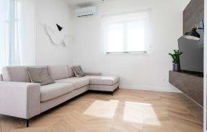 a living room with a white couch and a wooden floor at Villa Thora in Podorljak