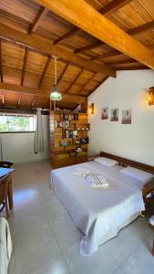 una grande camera da letto con un grande letto e un soffitto in legno di São Sebastião - Suíte privativa na praia a São Sebastião