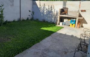 グアレグアイチュにあるCasa Coverの塀の横に緑の芝生がある庭 +2枚の写真