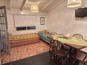 a room with a bed and a table and chairs at La Casita de Mogotes in Mar del Plata