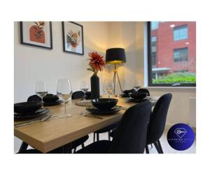 a wooden table with chairs and wine glasses at Modern City Centre Apartment in Exeter +21 photos