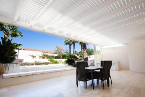 d'une terrasse avec une table, des chaises et une pergola blanche. dans l'établissement VILLA DELFINI 2-12 Pax, à San Vito Lo Capo