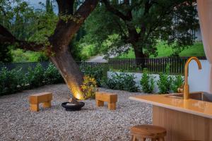 a backyard with a tree and benches and a sink at Villa Emelie in Dubravka