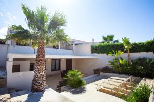 une maison avec un palmier devant dans l'établissement VILLA DELFINI 2-12 Pax, à San Vito Lo Capo