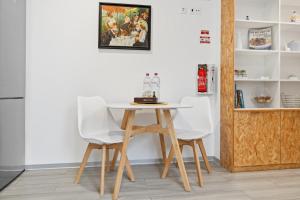 een tafel en twee witte stoelen in een kamer bij Indigo Apartment By The Madeira Luxury Collection in Funchal