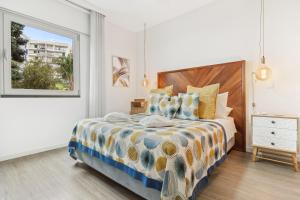een slaapkamer met een groot bed en een raam bij Indigo Apartment By The Madeira Luxury Collection in Funchal