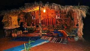 a room with a large straw hut with people in it at Camp Abrib merzouga in Merzouga