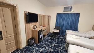 a hotel room with a bed and a tv at فندق جادة الغمامة in Medina