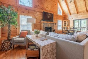 ein Wohnzimmer mit Sofa und Fernseher in der Unterkunft Cozy Spacious Cabin with Hot Tub, BBQ near Parkway in Pigeon Forge