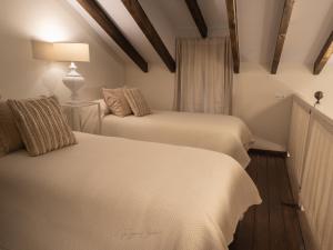 a bedroom with two beds and a lamp on a wooden floor at El Trastero Suite in Montellano